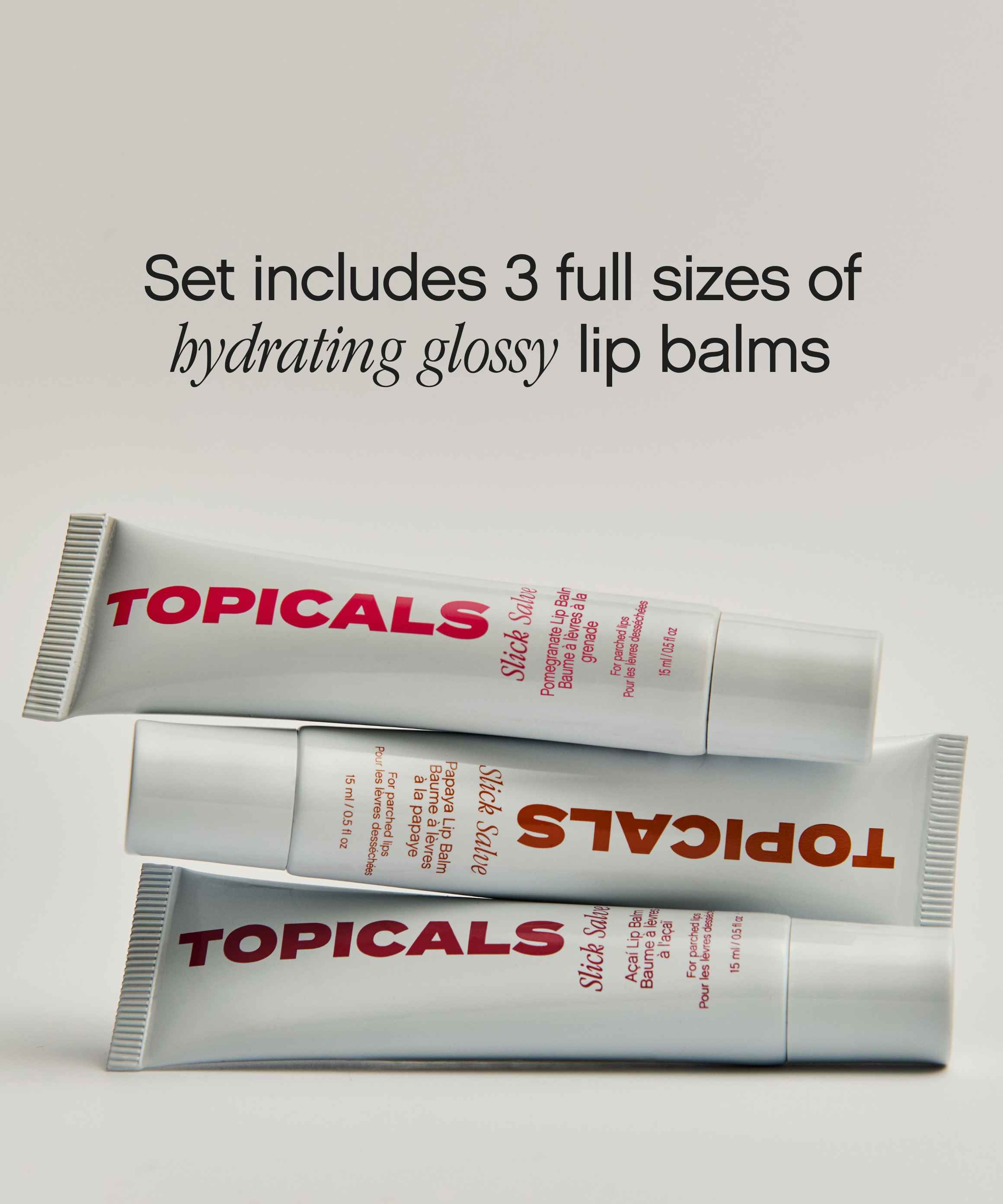 Three full-size Topicals Slick Salve hyaluronic acid lip balm tubes stacked on a beige backdrop, sold as a glossy lip balm trio set.