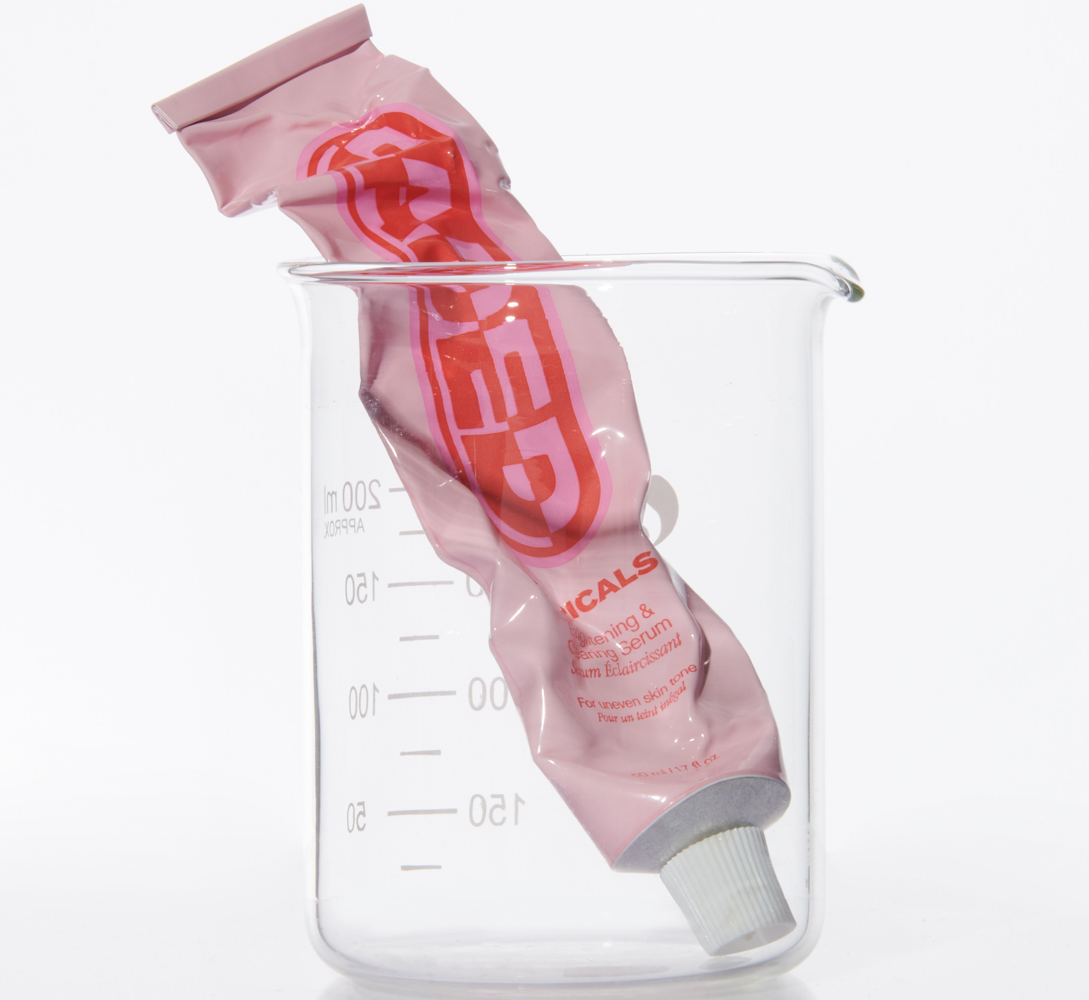 Topicals Faded serum tube squeezed inside a clear laboratory beaker, shown as a serum for dark spots and hyperpigmentation.