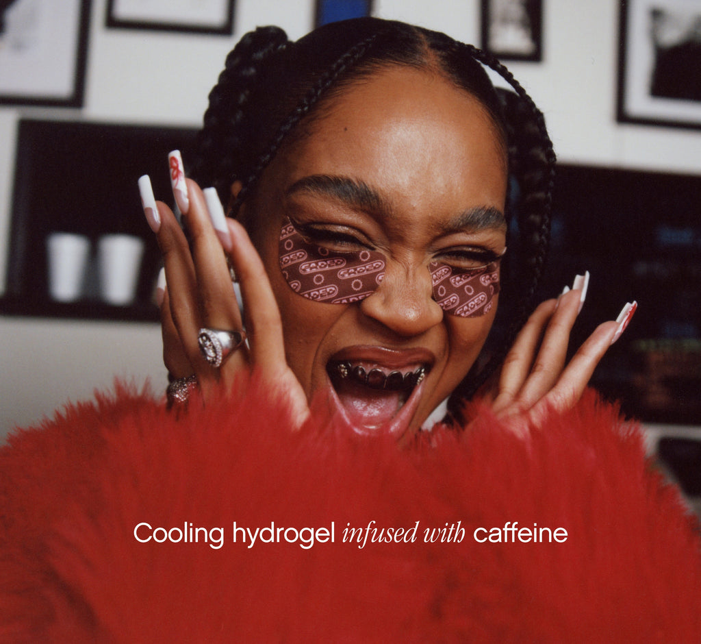Brightening under eye patches from Topicals Faded in brown worn by a laughing woman with box braids and a red feathered outfit, with text noting the cooling caffeine-infused hydrogel formula.